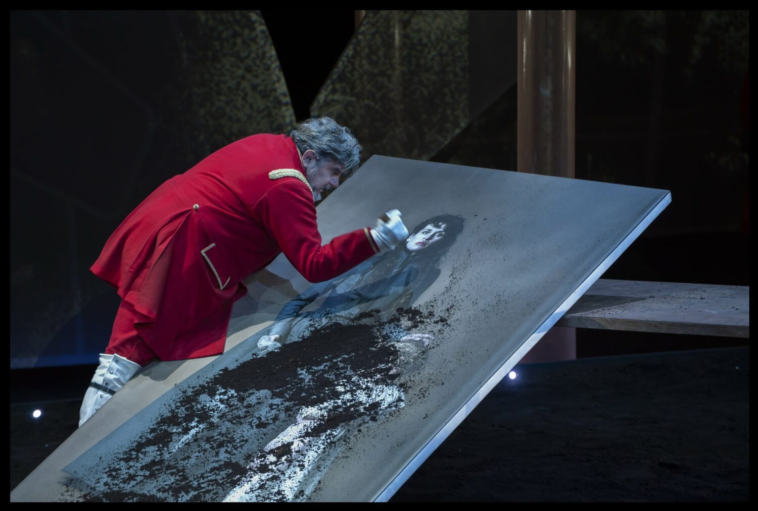 Abgründiger „Don Karlos“: Philipp II. (Bruno Cathomas) zerschneidet die Bilder seiner Gemahlin und Tochter.