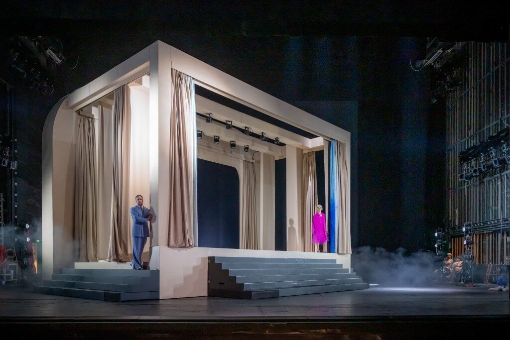 Blick auf eine Bühne auf die ein Kasten mit Vorhängen steht.