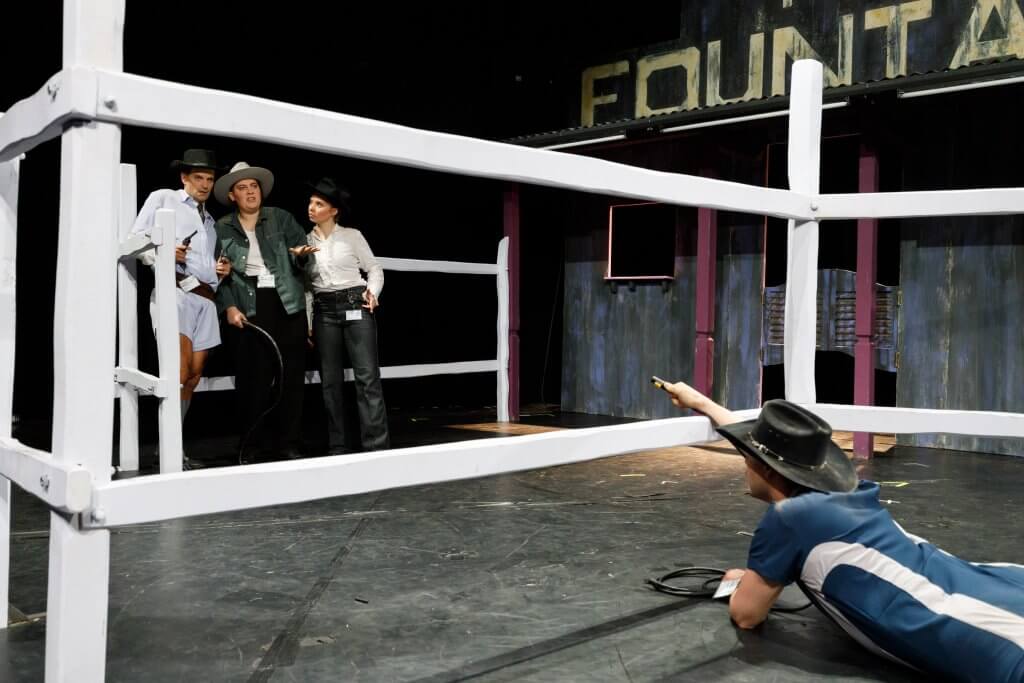 Eine Person liegt auf dem Boden und scheint eine Gruppe weitere Menschen anzubetteln.