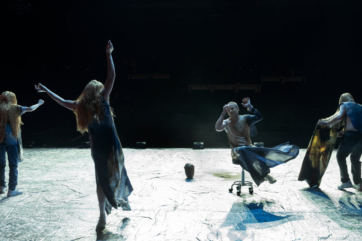 Barbara Nüsse (Chor), Patrycia Ziolkowska (Chor), Sebastian Zimmler (Bote) und Sebastian Rudolph (Chor) interagieren auf der Bühne. Der Hintergrund ist dunkel, der Bühnenboden hell erleuchtet.