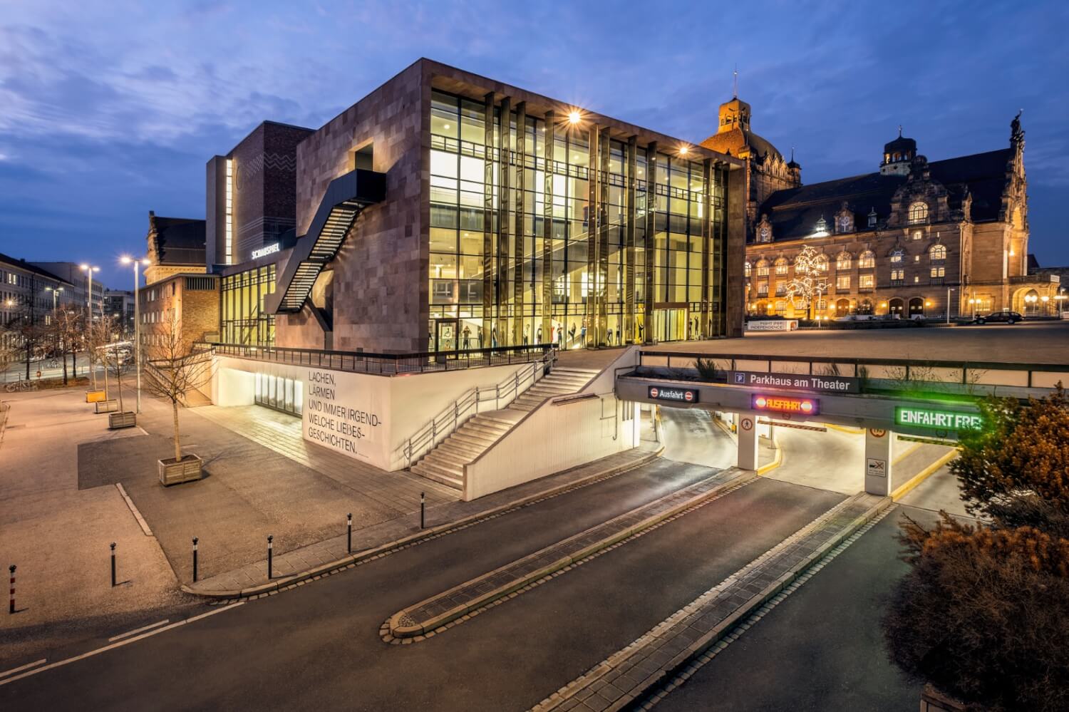 Zu sehen ist im Vordergrund das Schauspielhaus und im Hintergrund das Opernhaus des Staatstheater Nürnberg bei Dämmerung.