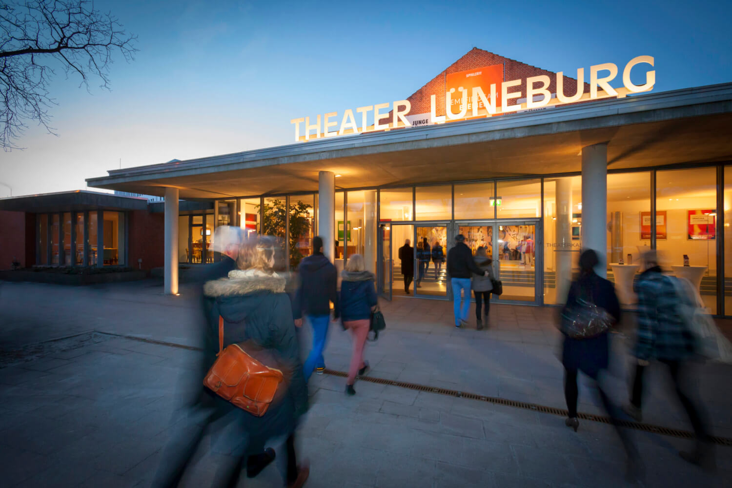 Man sieht den Eingang des Theater Lüneburg in der Dämmerung
