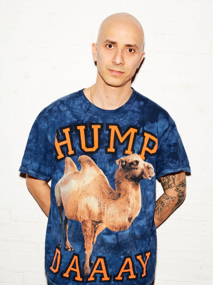 Zu sehen ist Guy Weizman, auf dessen blauen T-Shirt ein Kamel ist.