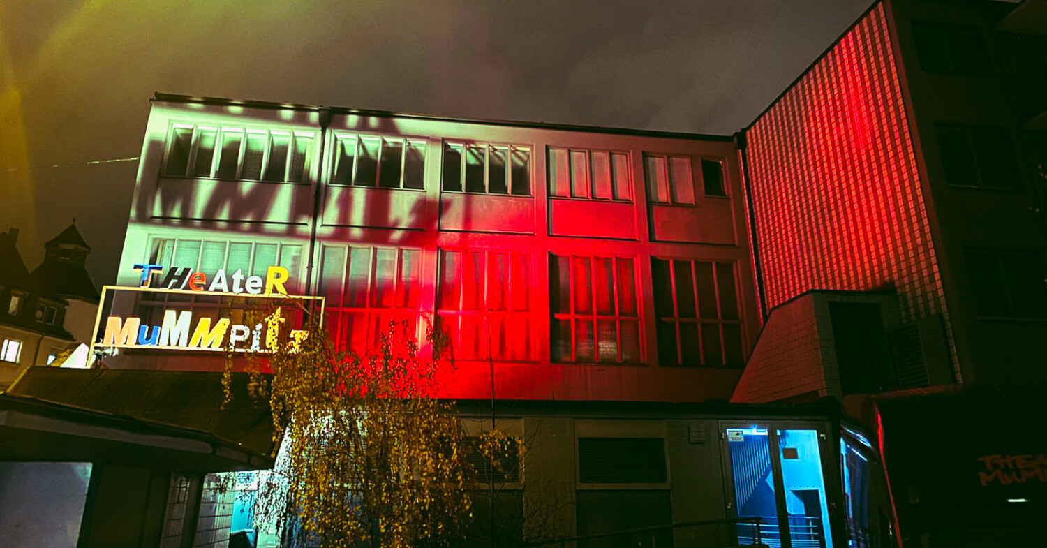 Zu sehen ist das Theater Mummpitz rot angeleuchtet bei Nacht