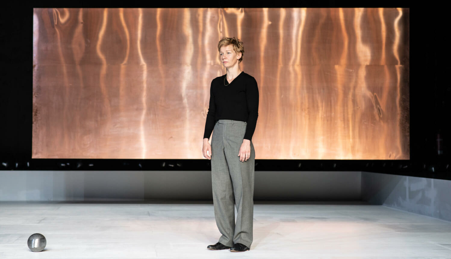 Sandra Hüller steht vor einem flammenden Hintergrund