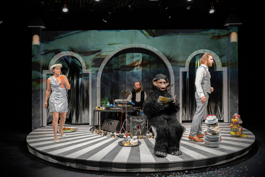 Tischgesellschaft aus dem Ruder: Alice Katharina Schmidt, Ulrich Hartmann und Ole Xylander in Hugo von Hofmannsthals „Jeder*mann“ an der Badischen Landesbühne. Foto: Dominique Brewing