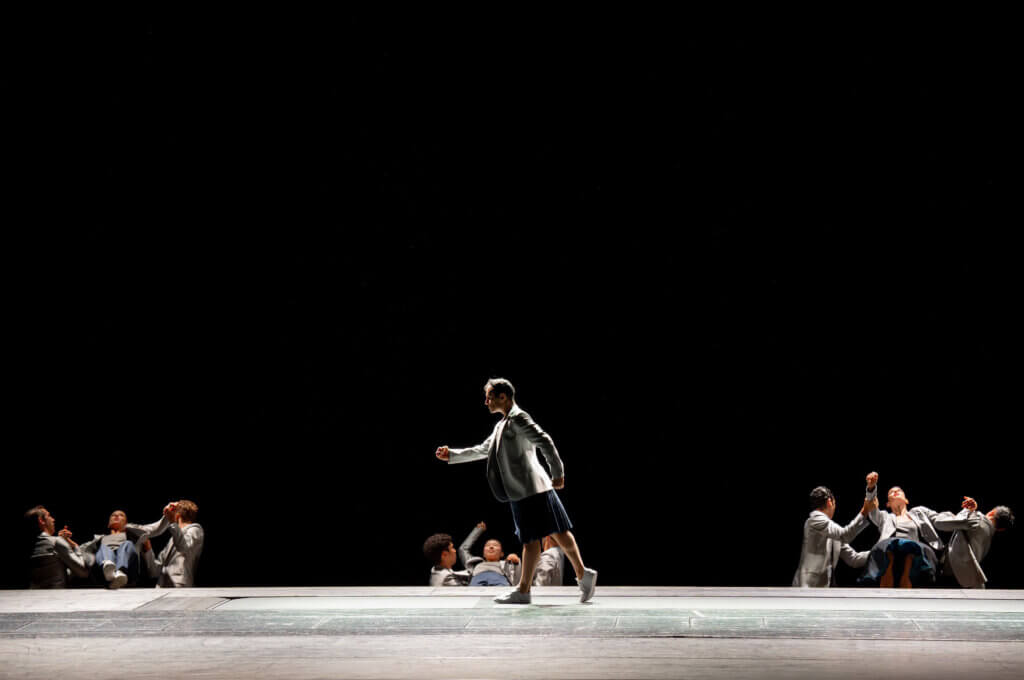 Eine Person läuft von rechts nach links über die Bühne.