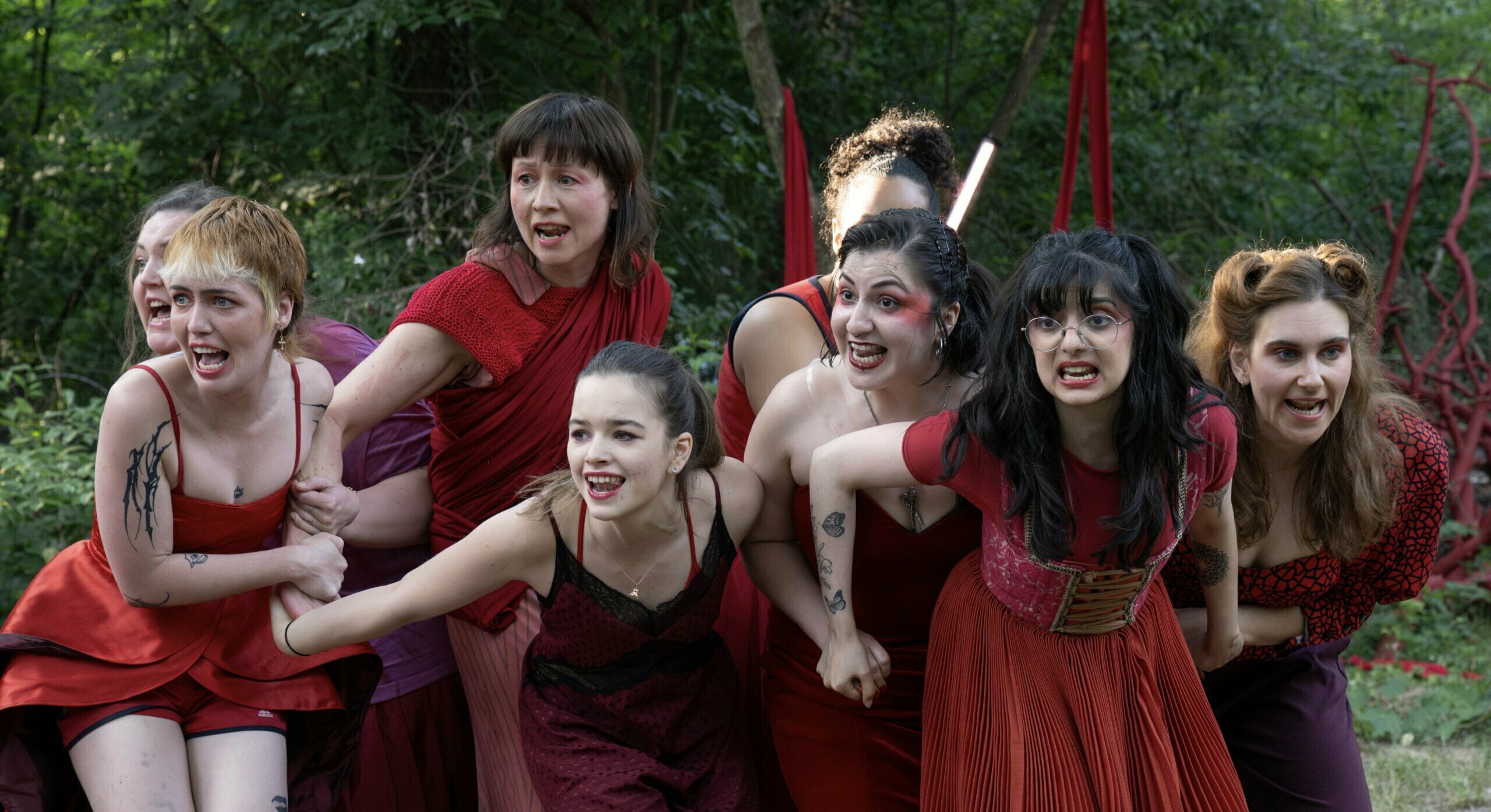 junge Darsteller:innen alle rot gekleidet, die chorisch sprechen