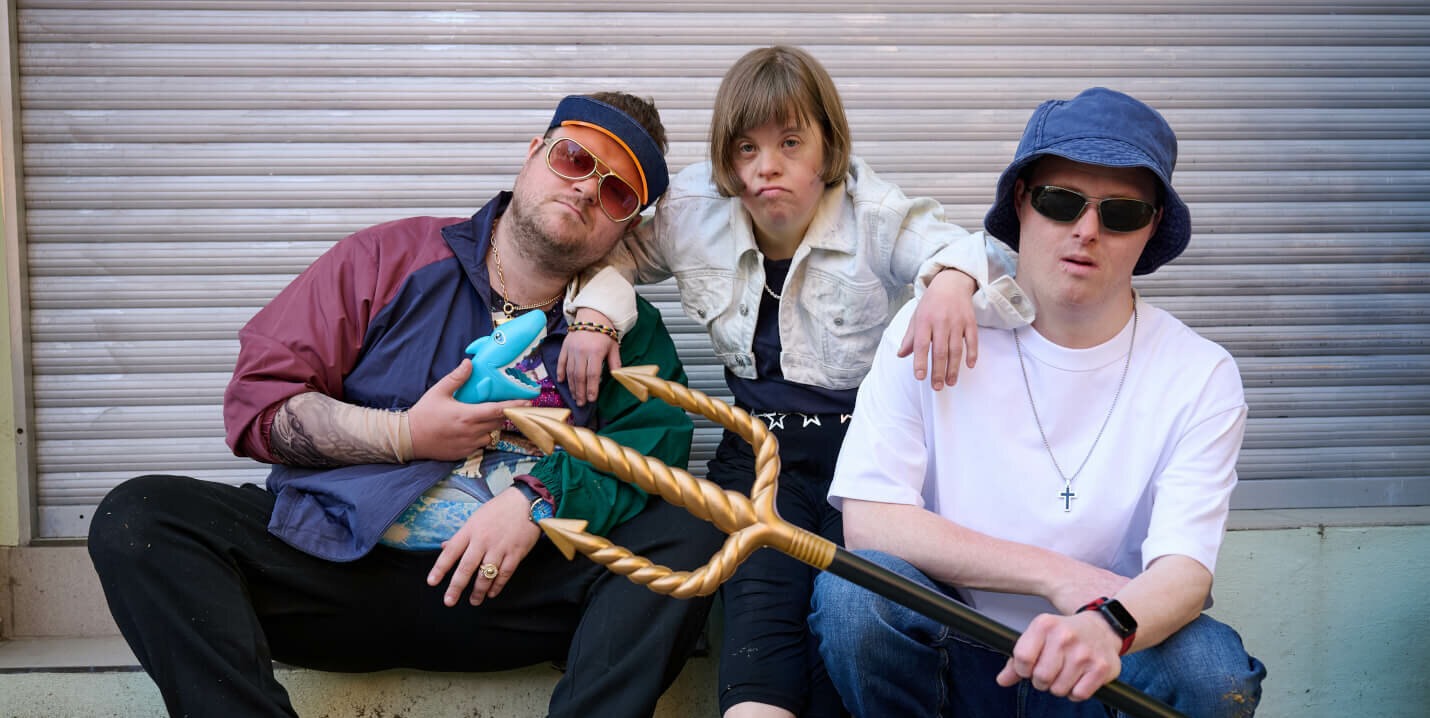 Drei Menschen sitzen nebeneinander, sehen cool aus