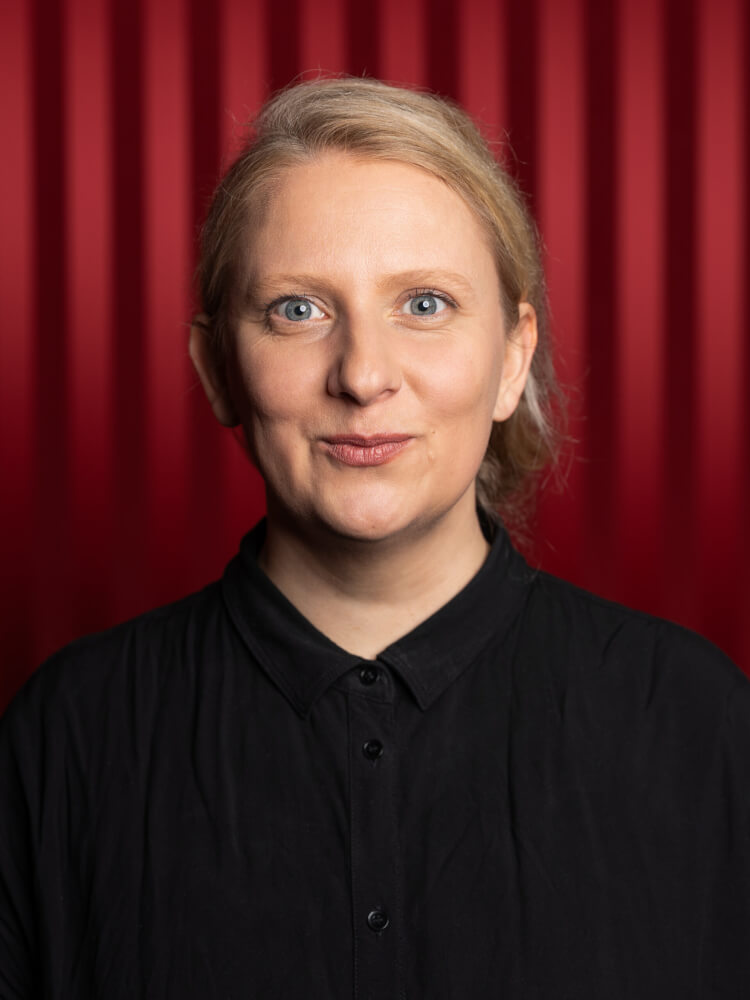 Zu sehen ist Gabriele Gillert, Leiterin Junges Theater am Staatstheater Meiningen, vor einem roten Vorhang