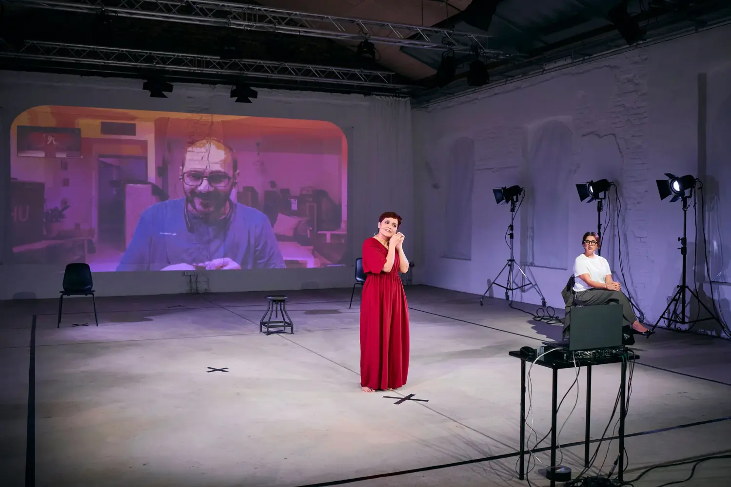 Drei Darstellende, einer im Video an der Rückwand