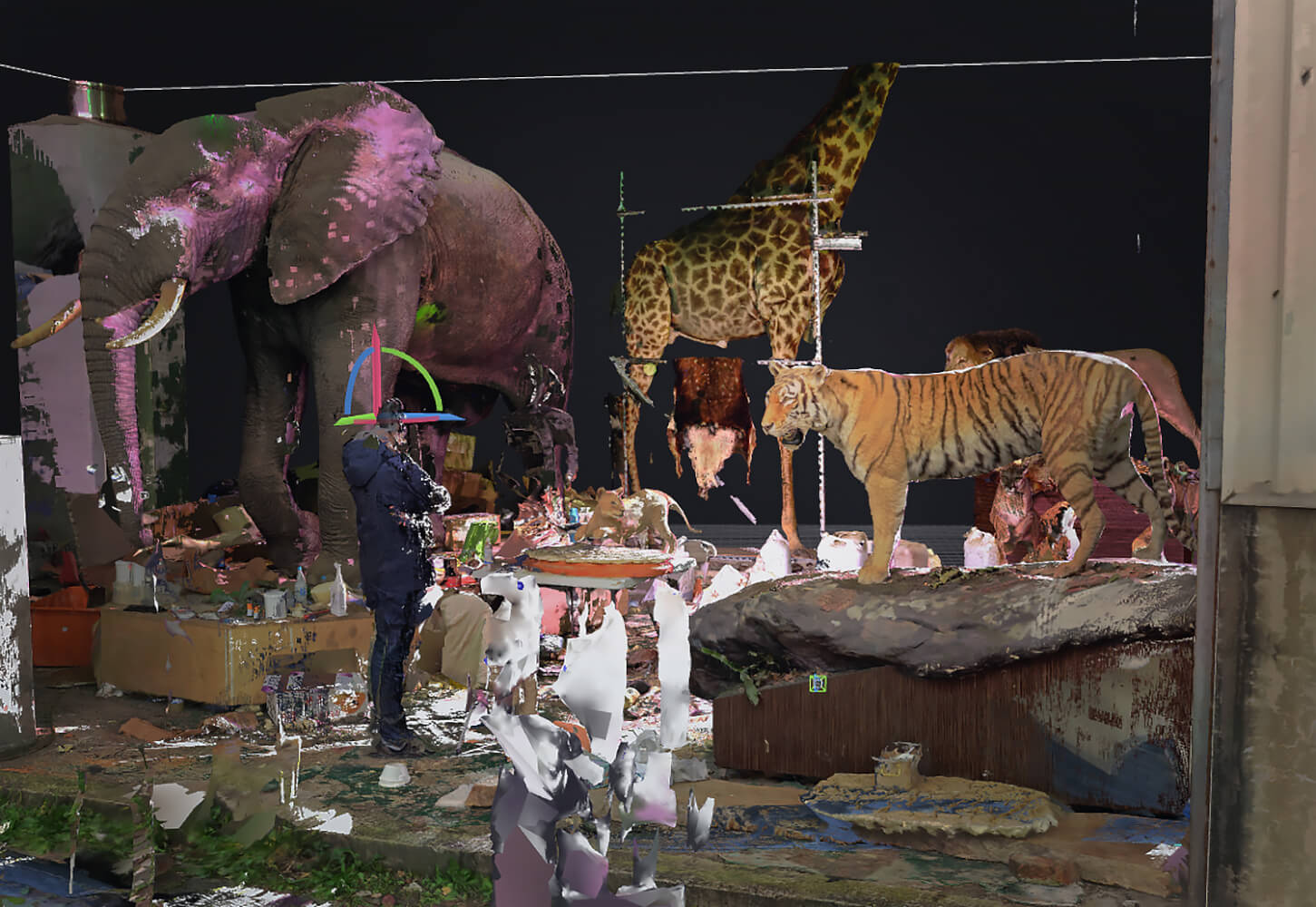 Aufführungsfoto von „The Zoo Hypothesis“, eine Videoinstallation und Lecture-Performance von Hsu Che-Yu. Stellenweise verpixelt sind auf der Bühne von links nach rechts ein Elefant, eine Giraffe, Löwe und Tiger. Davor eine Person, deren Kopf man nicht erkennen kann, die die Tiere betrachtet.