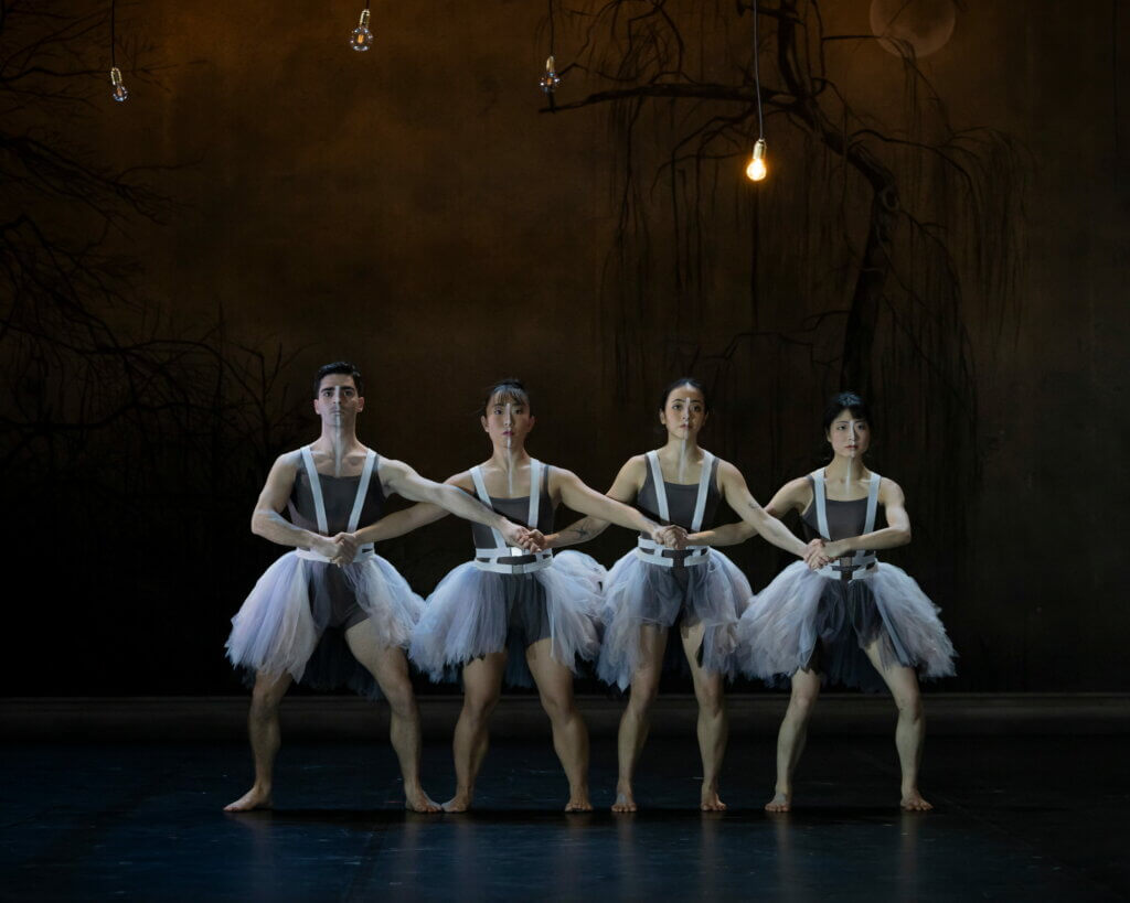 Vier Tänzer:innen stehen in Formation nebeneinander auf der Bühne im Theater Münster.