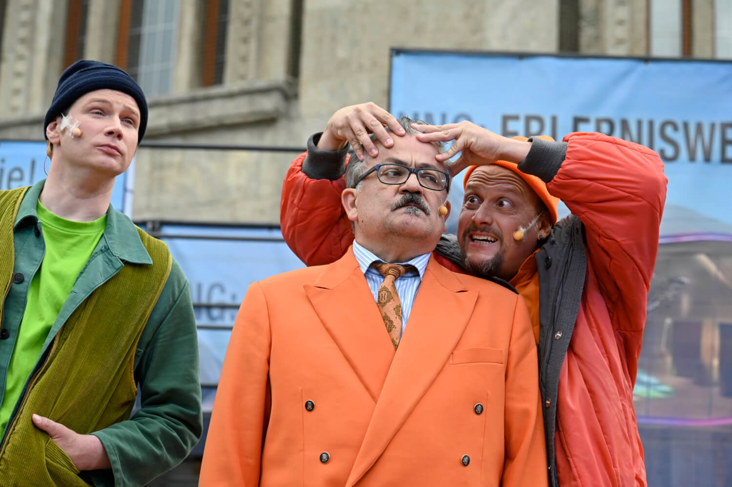 Frank Auerbach steht links und blickt nach vorn. Daneben massiert Henning Z Bäcker Marc Vinzing die Stirn.